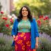 Sebavedomá plus size žena v štýlovom farebnom oblečení v rozmazanej mestskej záhrade.